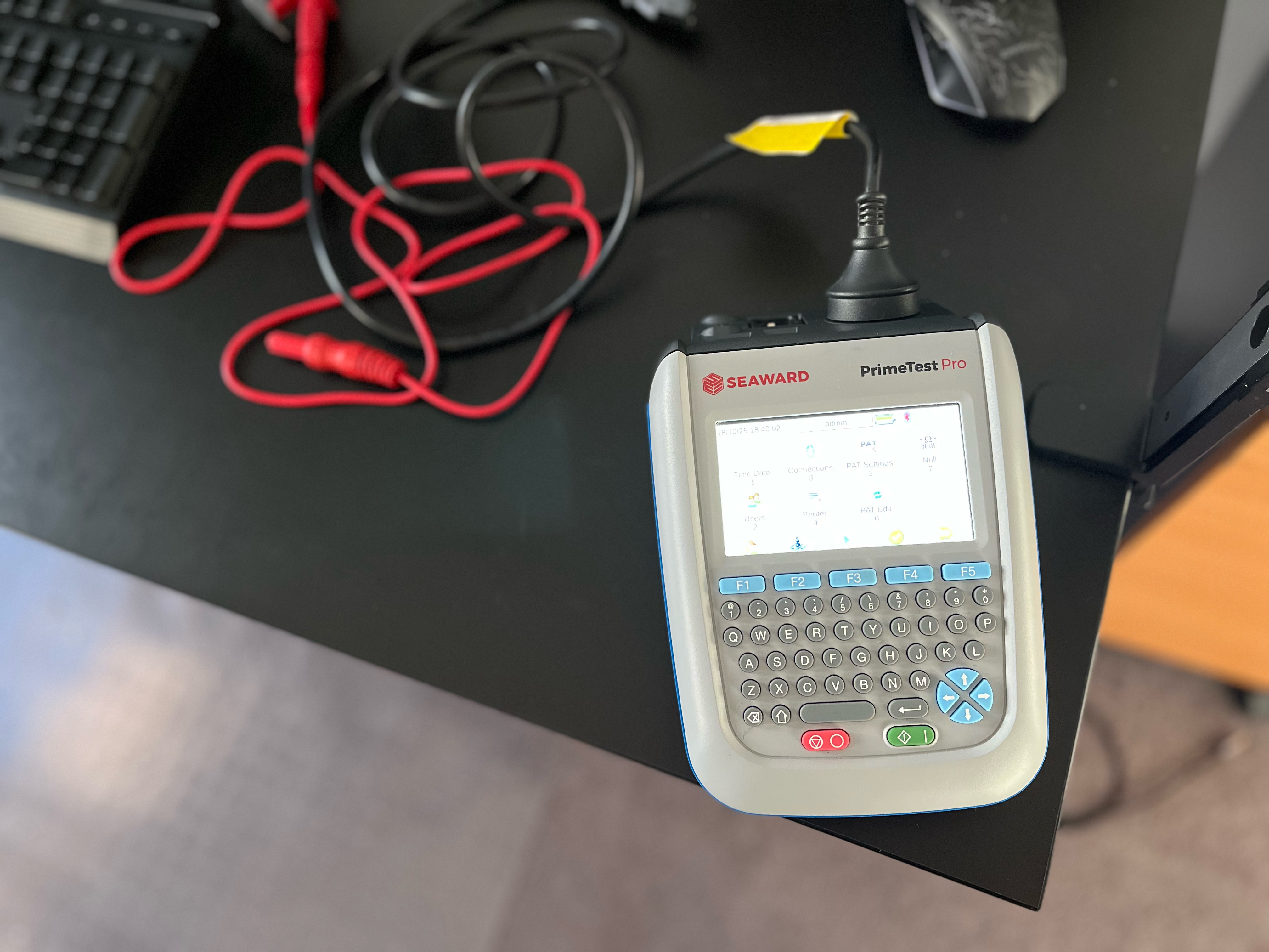 Technician with hard hat and safety gloves testing electrical equipment at a Melbourne workplace