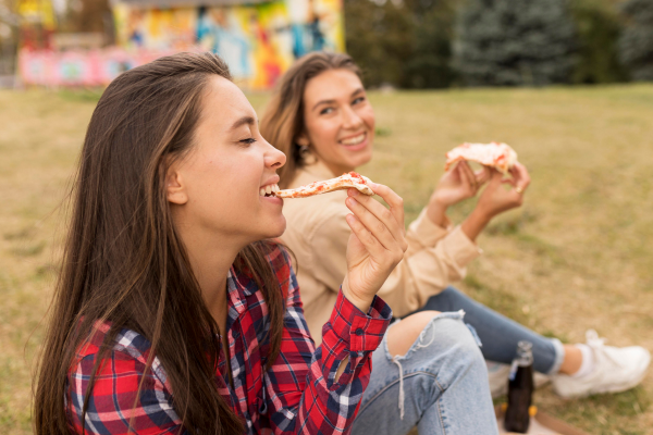 a happy lesbian couple eating pizzas together