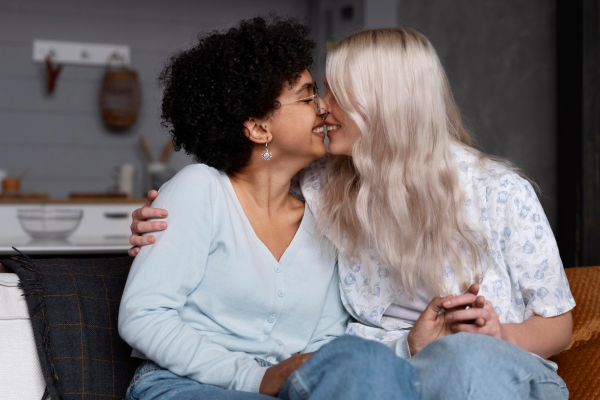 a lesbian couple kissing on the couch