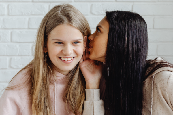 lesbian couple whispering to one another