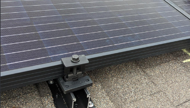 New roof attachment and flashing under a reinstalled solar panel on a shingle roof