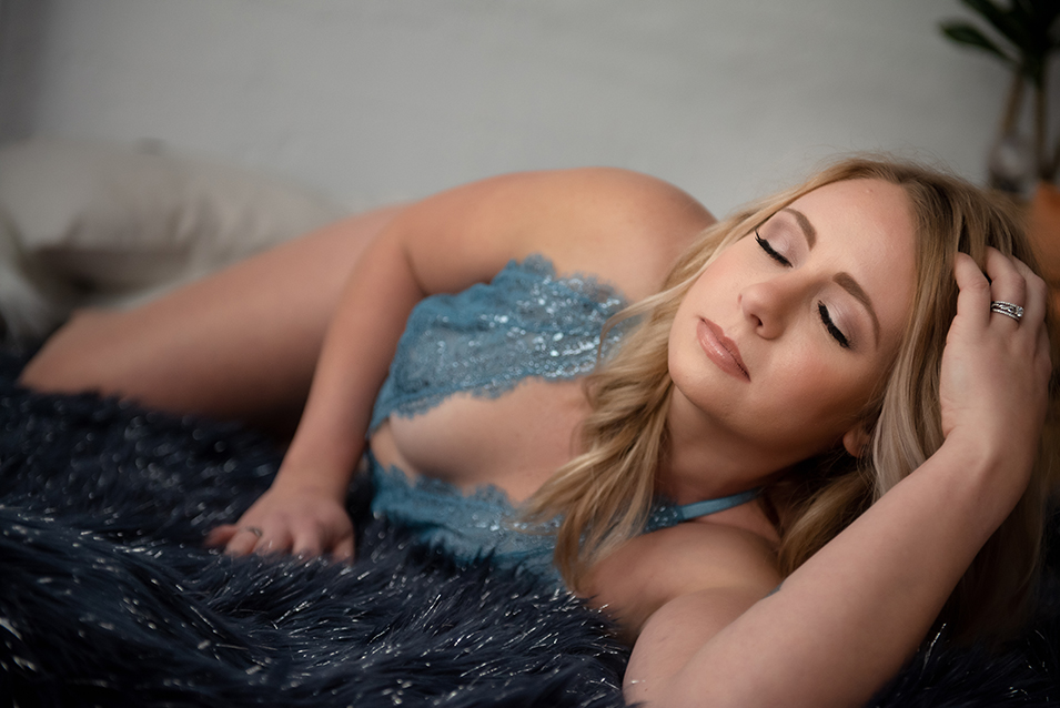 woman laying down, wearing blue lingerie