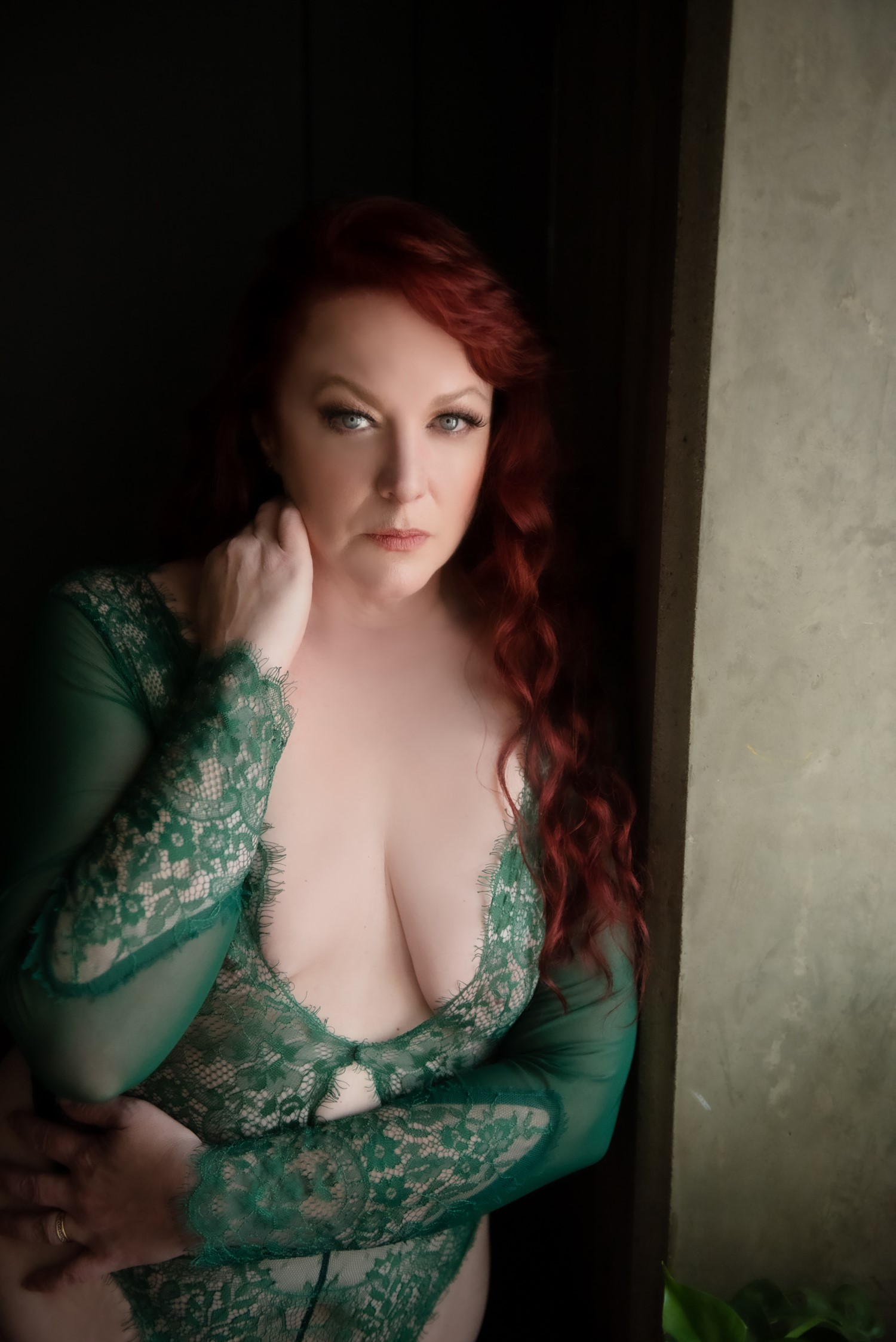 red-haired woman wearing emerald green lingerie