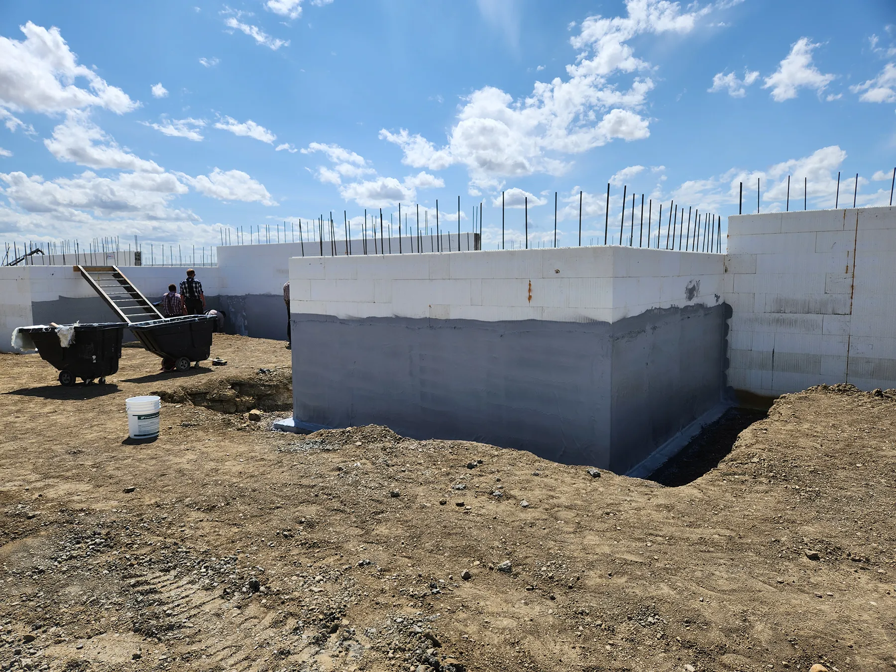 ICF foundation wall construction showing stacked insulated forms and fire-rated Hulk Acrylic Waterproofing applied and bonded directly to ICF foam exterior.