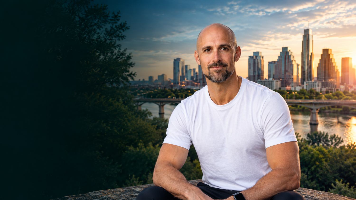 Jeremy, an Austin weight loss coach, sitting above Lady Bird Lake with the Austin skyline behind him at sunset