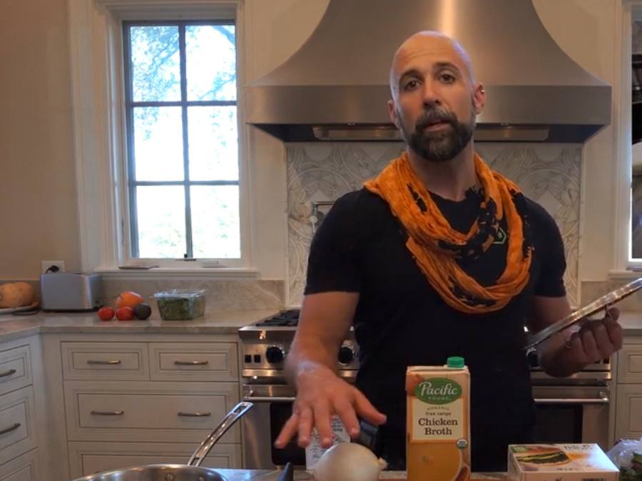 Jeremy in his kitchen explaining a whole-food plate with fresh produce on the cutting board