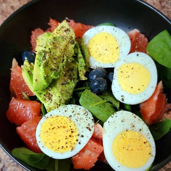 Eggs, avocado and grapefruit over greens