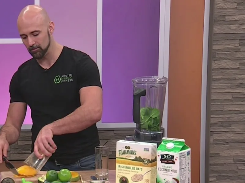 Jeremy Robinson slicing mango for a green smoothie, with limes, oats and a blender on the counter