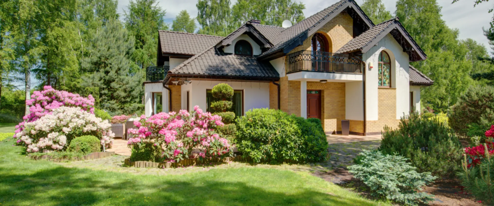 Colorful spring garden with blooming flowers and green lawn.