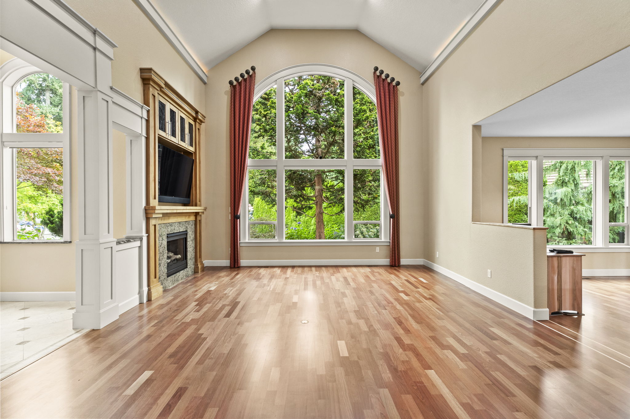 Living room with tall arched window and fireplace