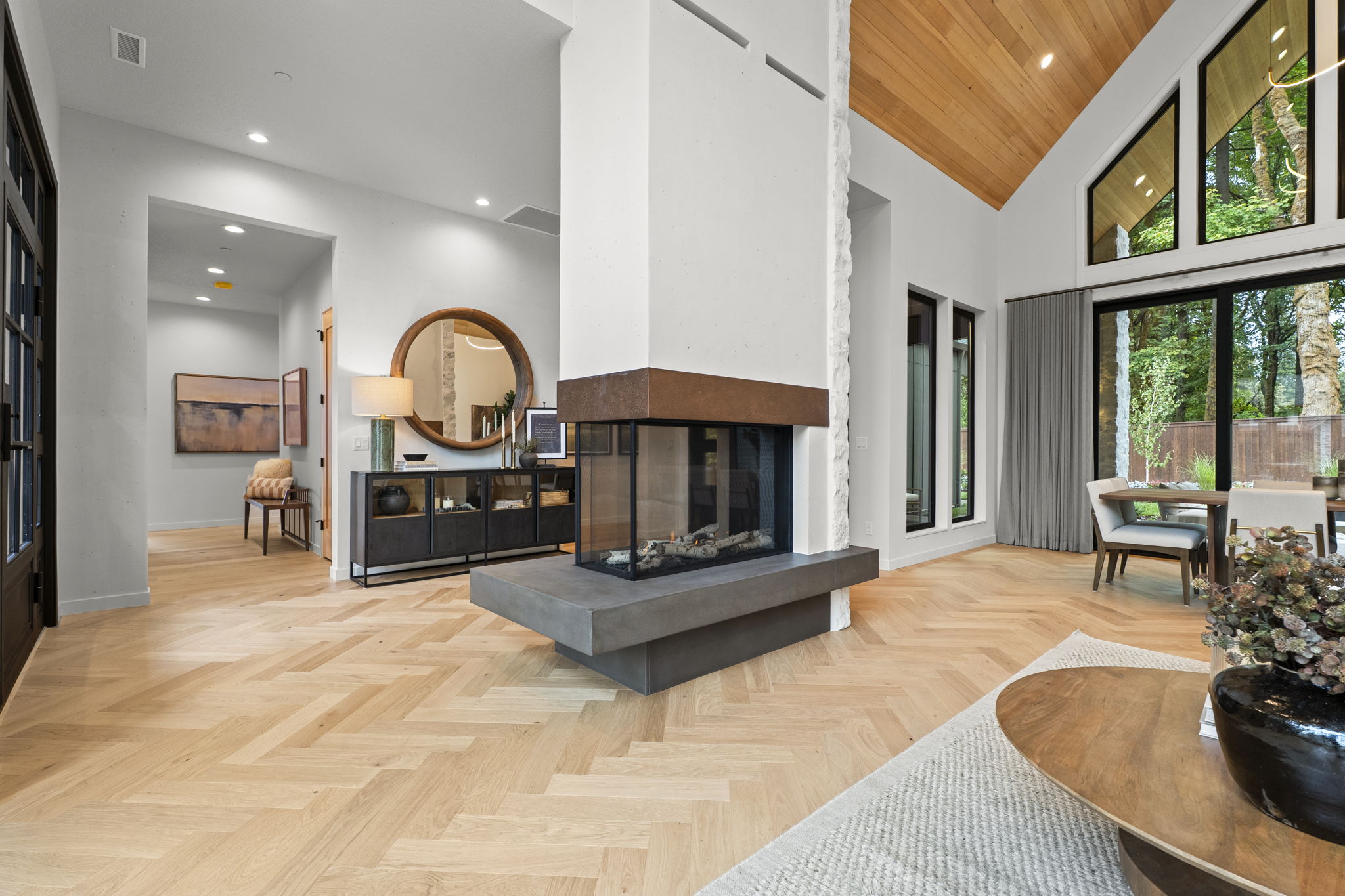Open-plan living room with stone fireplace and vaulted wood ceiling