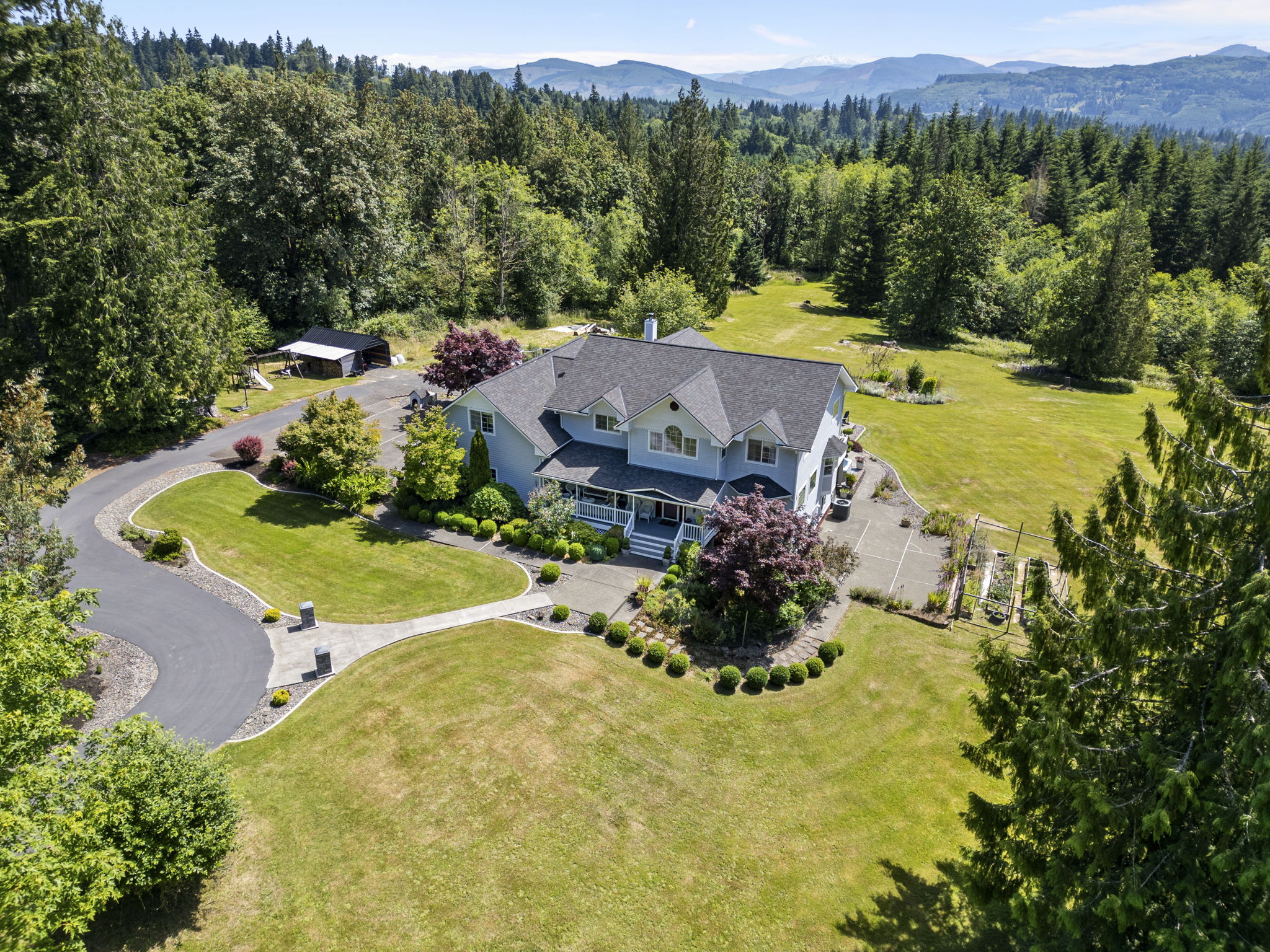 Aerial view of home and surrounding wooded acreage