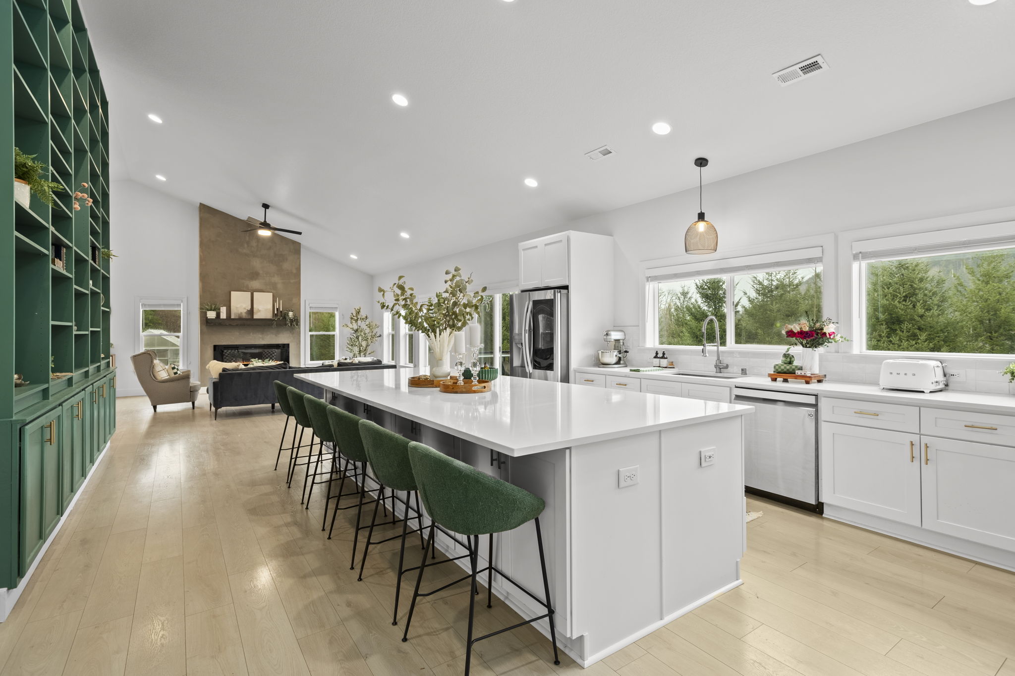 Spacious kitchen with green cabinetry and long island