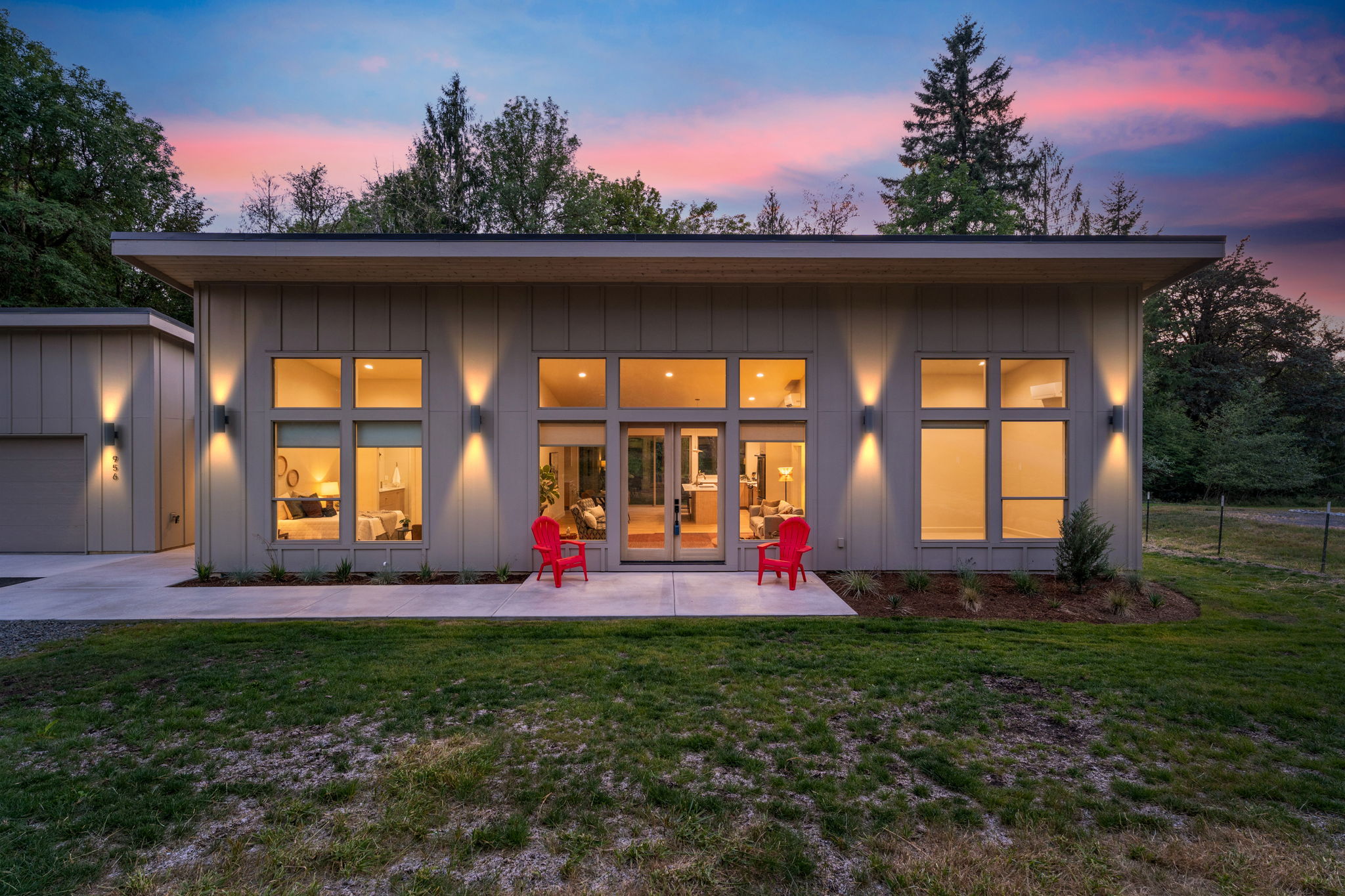 Modern home illuminated beneath a pink twilight sky