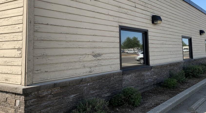 Damaged siding highlighting need for commercial property maintenance