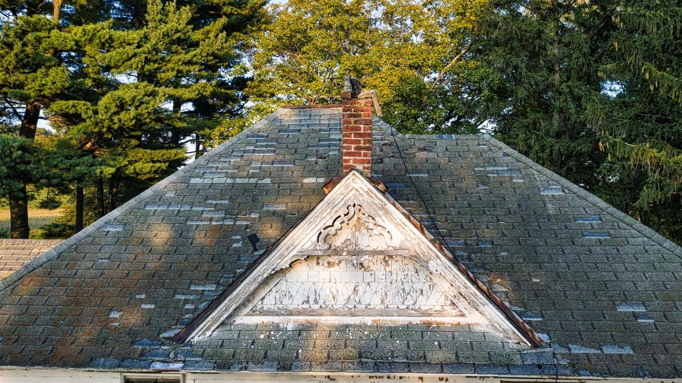 An older residential roof displaying clear signs you need a new roof.