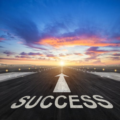 A road leading to the word Success at sunrise