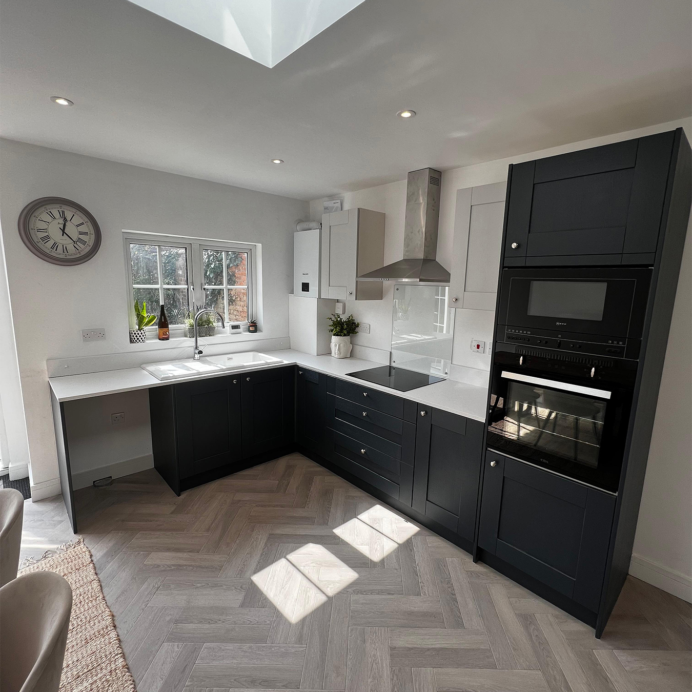 Dark handleless kitchen with herringbone floor