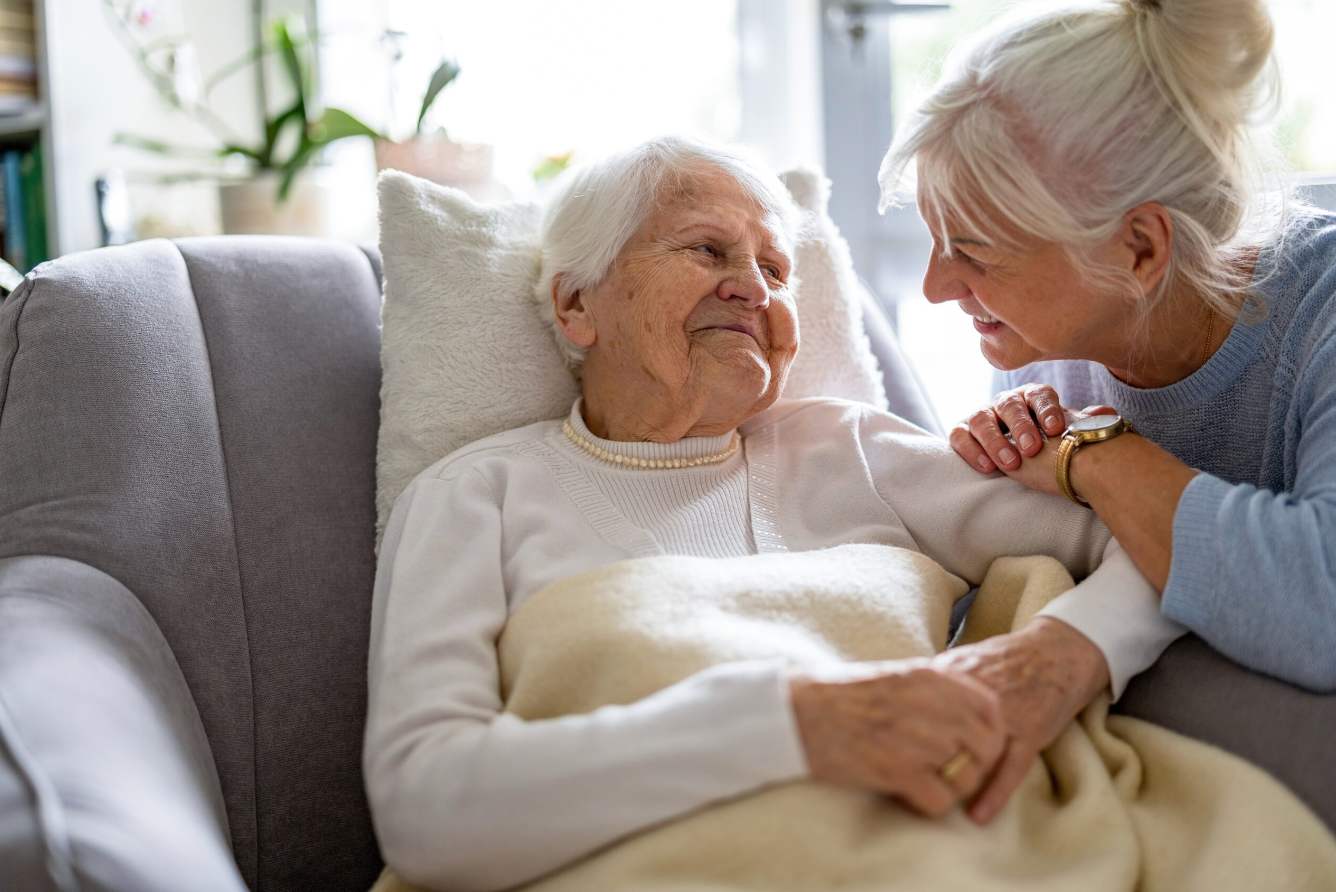An Apex carer gently holding a client's hand during a home visit in Berkshire