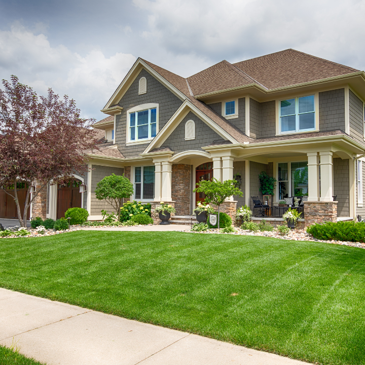 A beautiful two-story home with a well-maintained lawn and inviting curb appeal, perfect for showcasing real estate expertise.