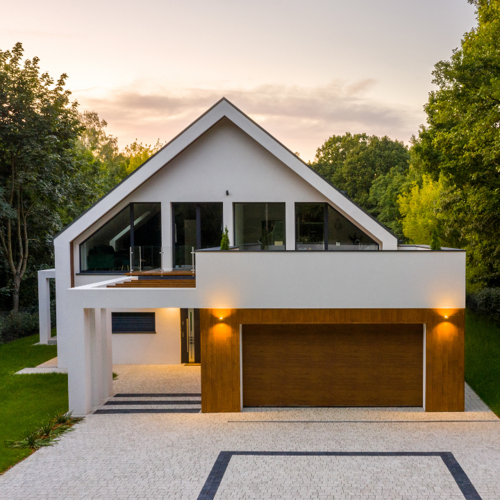 A sleek, modern home with large windows and a clean architectural design, surrounded by greenery.