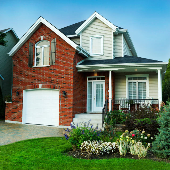 A stunning two-story home with a brick front and lush landscaping, highlighting a welcoming residential property.