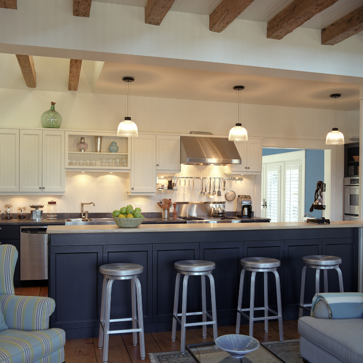 Modern kitchen with exposed wooden beams, sleek appliances, and a spacious island with bar stools, perfect for entertaining.