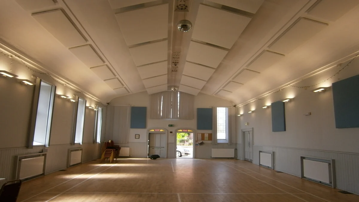 Acoustic ceiling panels inside Cromarty Victoria Hall, with an arched entrance at the far end.