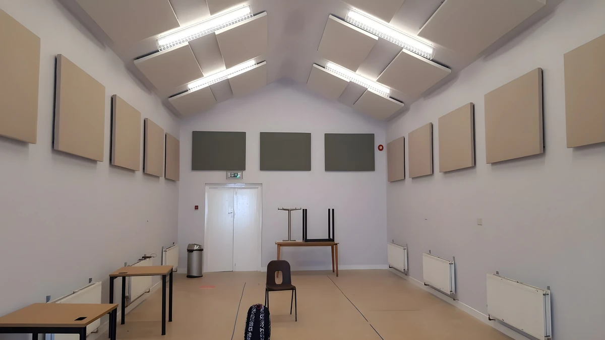 Beige and grey rectangular acoustic panels on the walls of a room at Auchtermuchty Community Centre, beneath a pitched white ceiling.