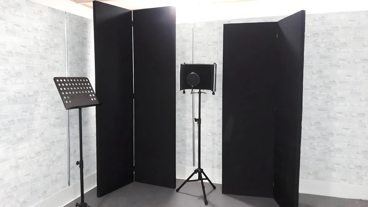Black free-standing acoustic panels arranged around a microphone, with a music stand alongside, at Giant Leap Productions.
