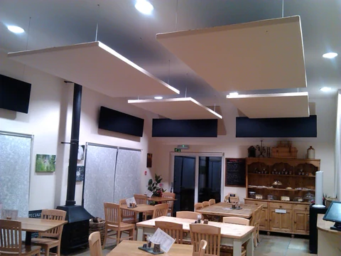 Suspended ceiling panels and dark wall panels above tables at Catch 23 café.