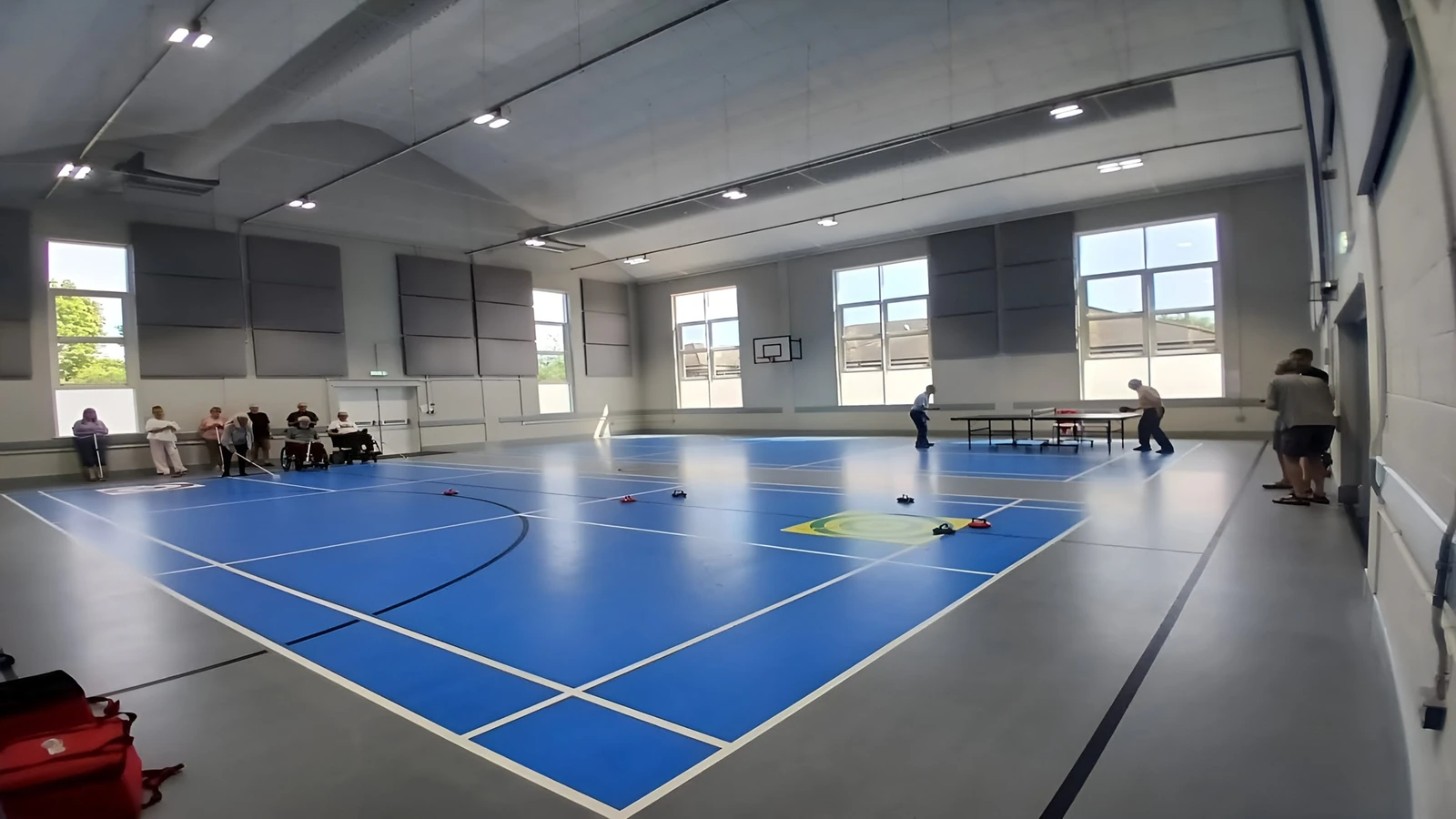 Grey acoustic wall panels above a blue marked sports court at Heathcote Community Centre.
