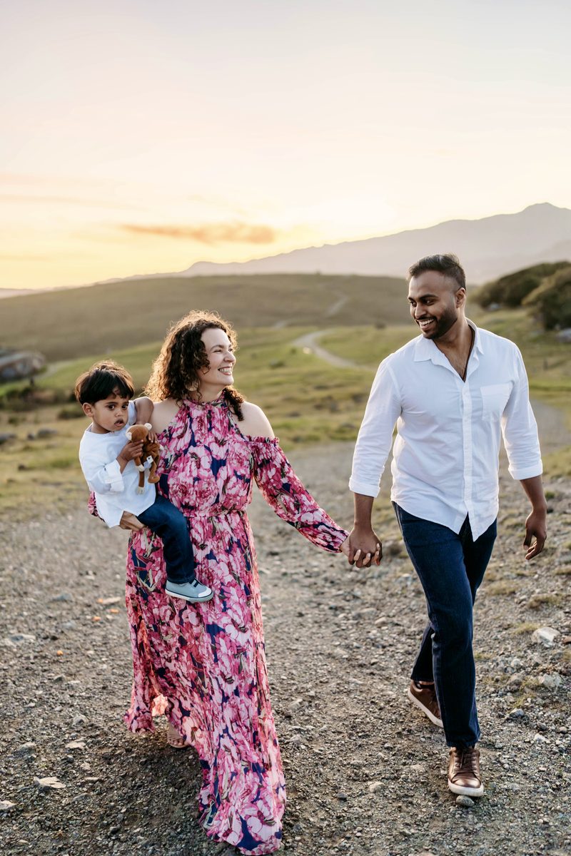 Adriana walking hand in hand with her family at sunset