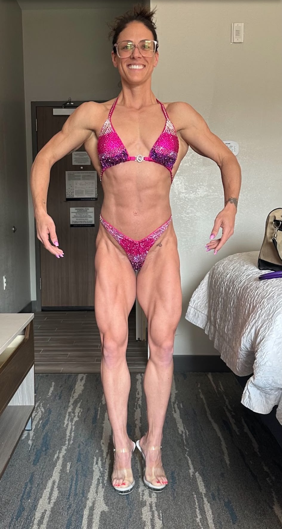Female bodybuilding champion posing in competition bikini