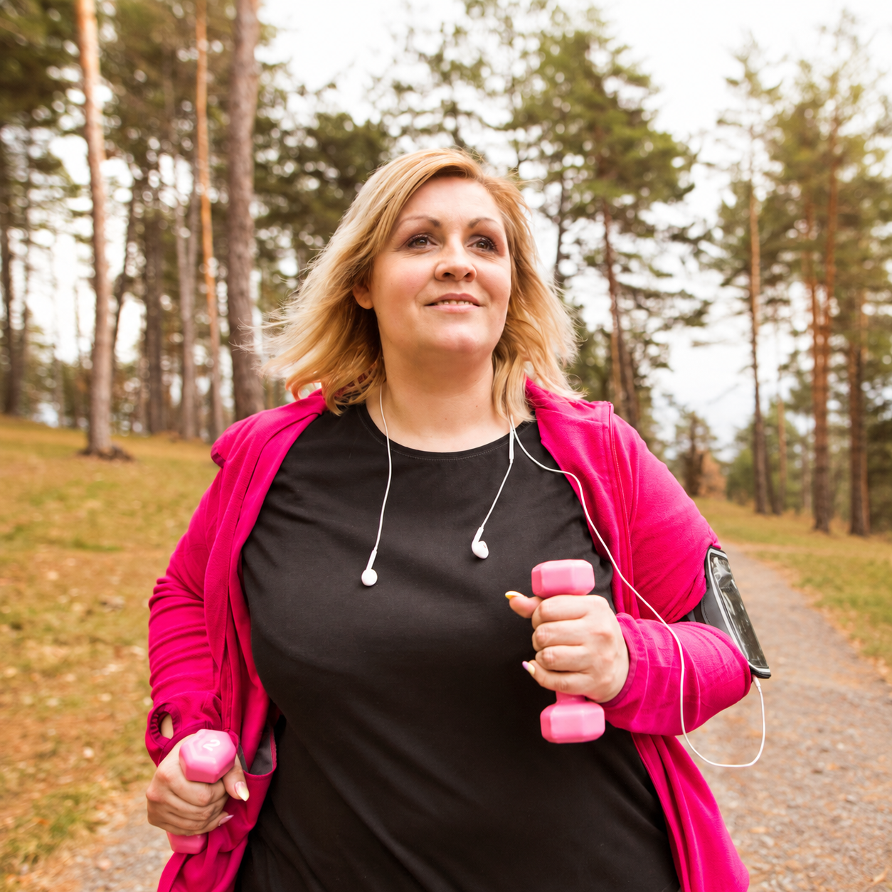 A woman exercising outdoors with hand weights