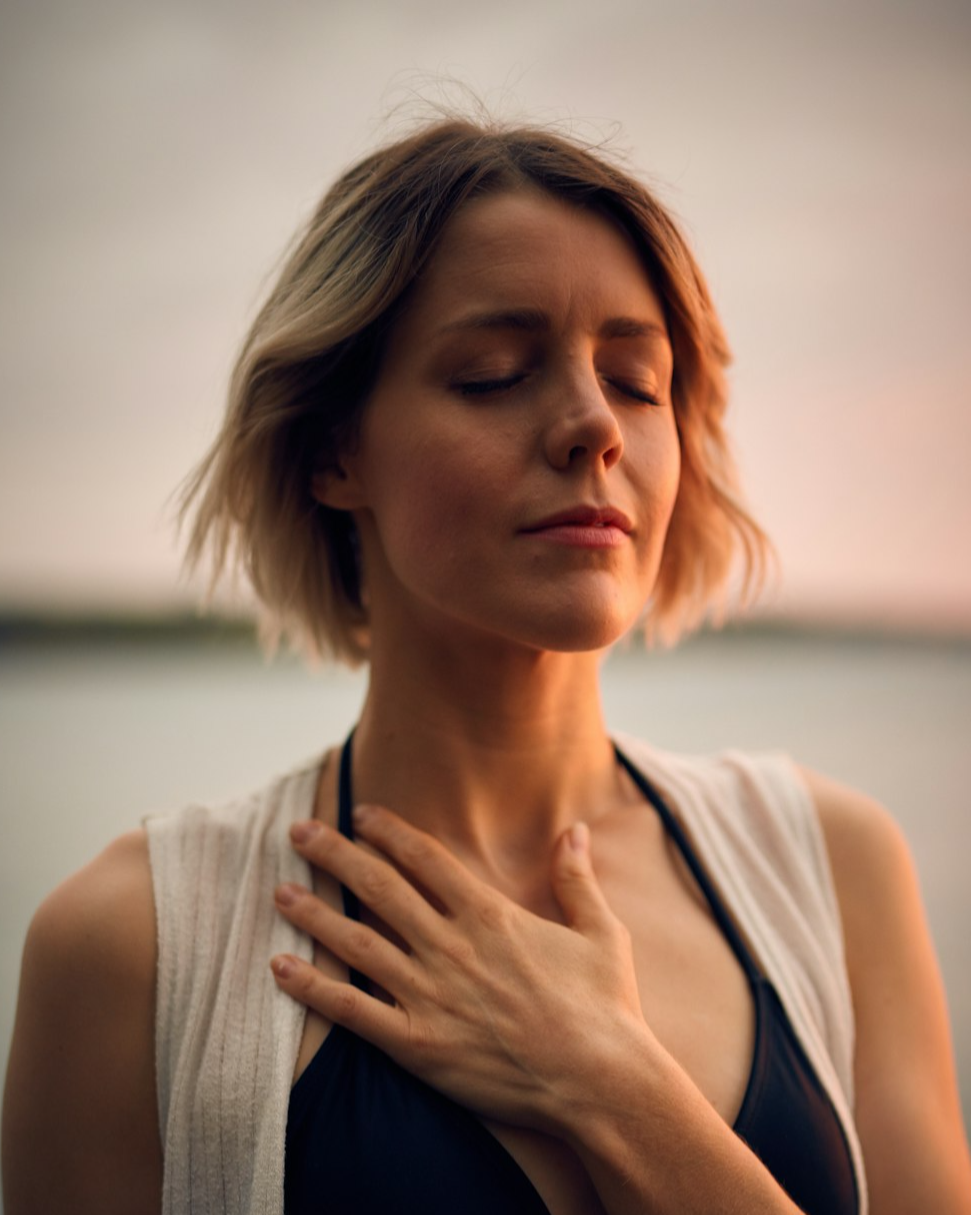 Woman with her hand on her chest. 