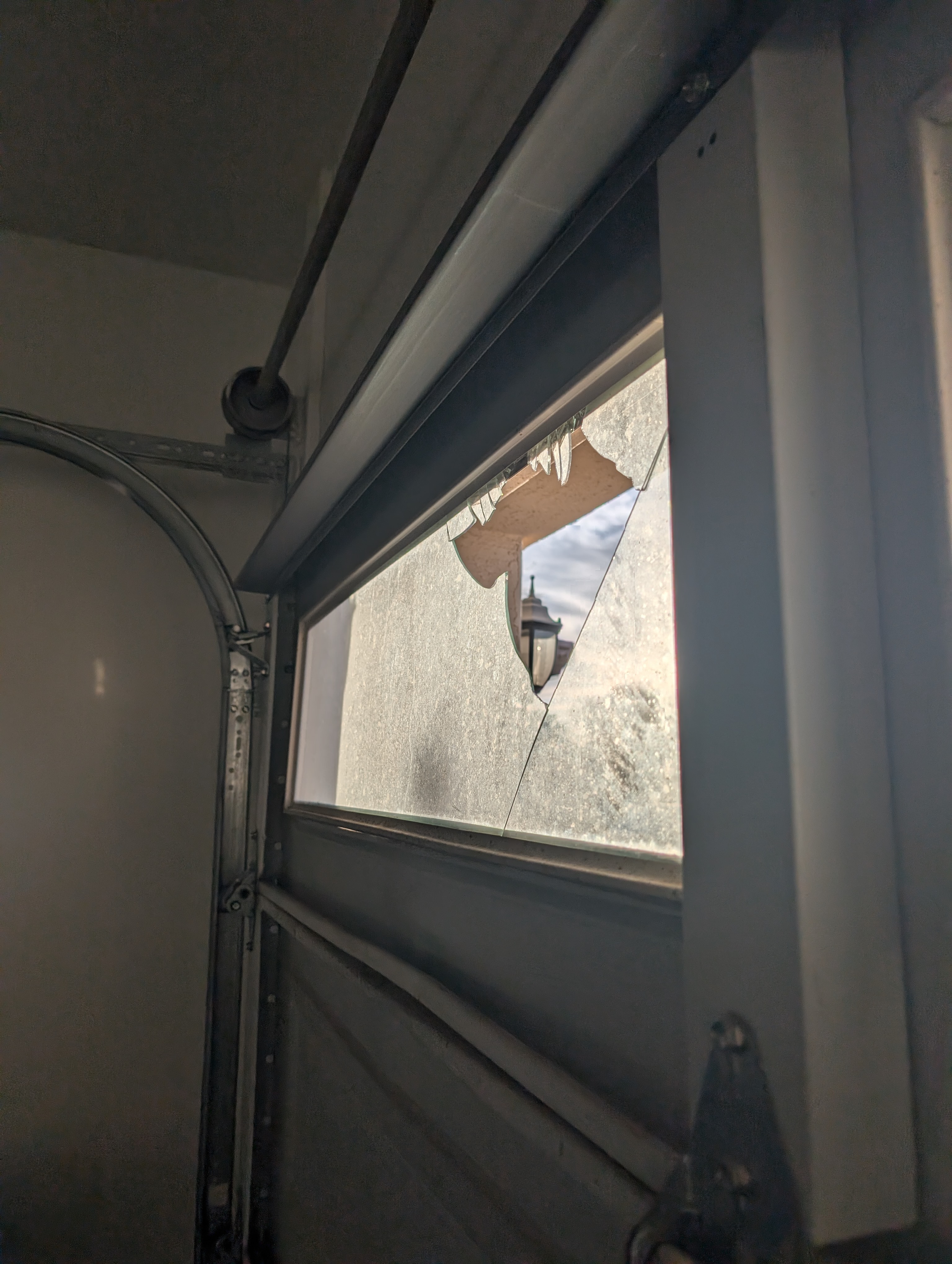 Hinged Overhead Door technician repairing a residential garage door