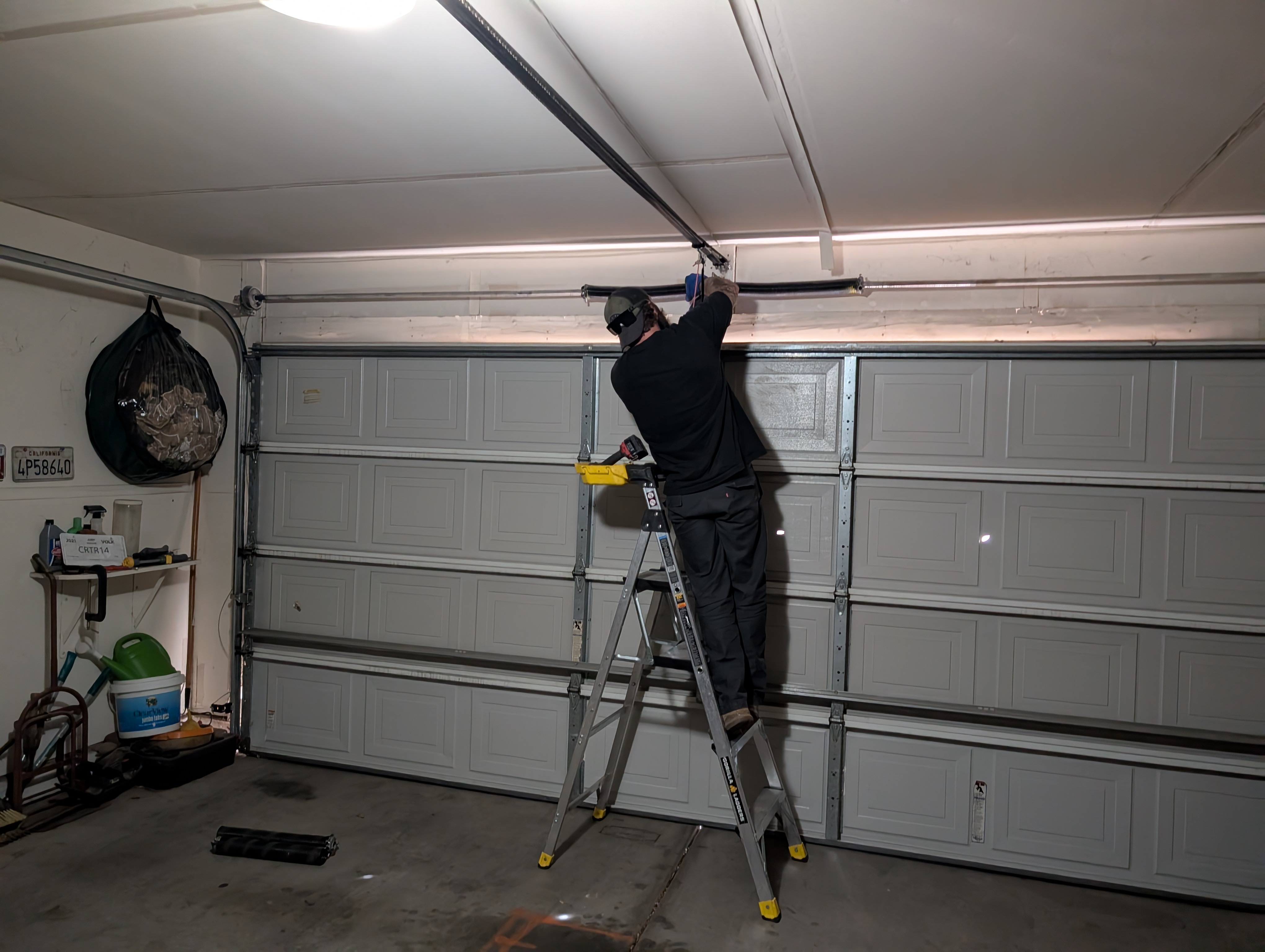 Garage door maintenance tune-up being performed by Hinged Overhead Door