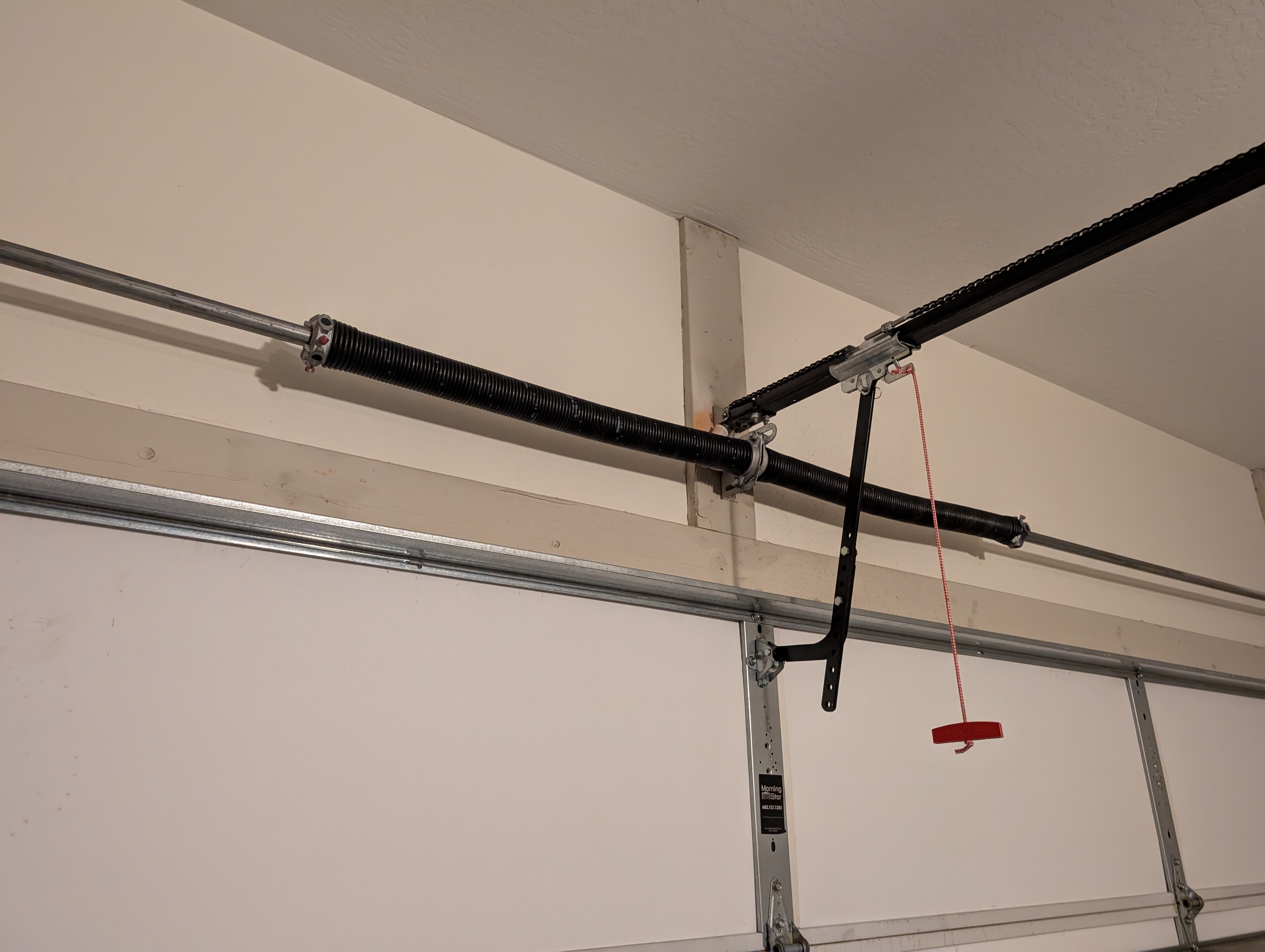 Garage door torsion spring being replaced by a Hinged Overhead Door technician