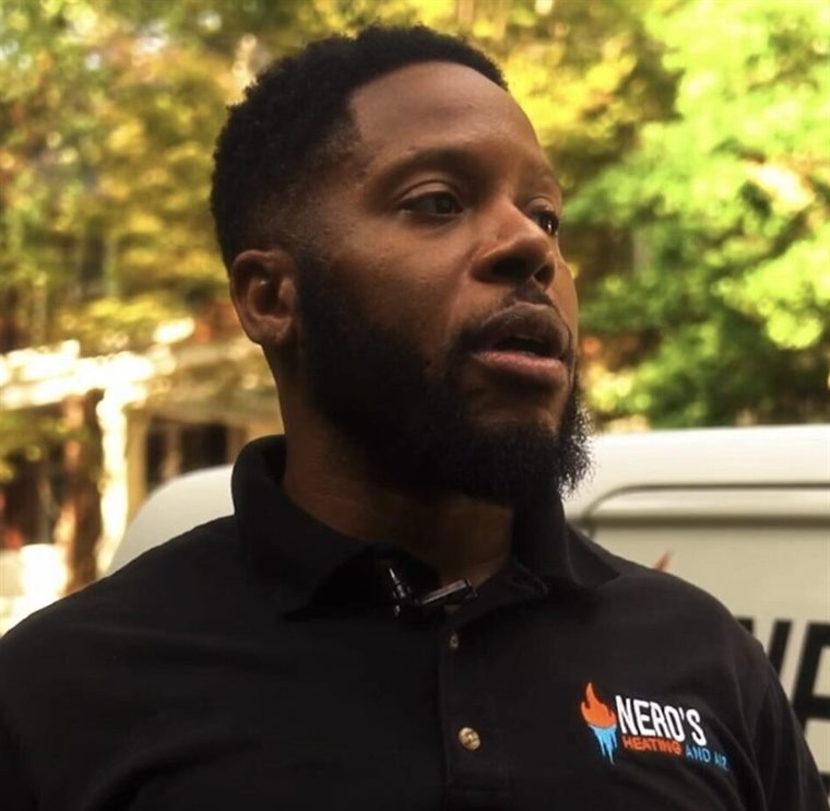 A Nero's Heating and Air team member in a company shirt