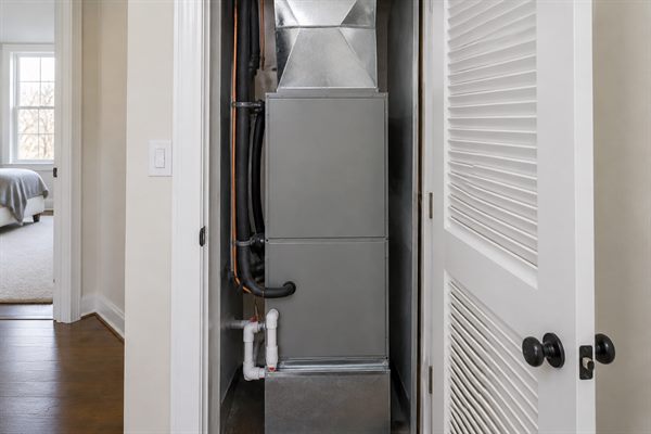 Vertical air handler with sealed ductwork and insulated refrigerant lines in a closet