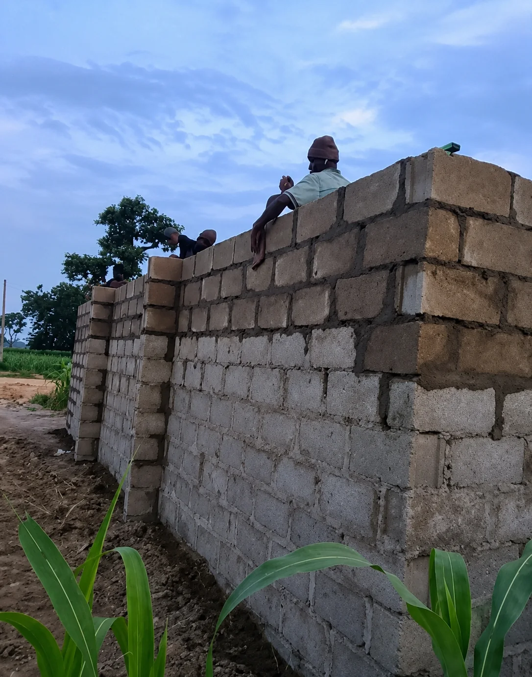 A worker on top of a rising block wall at the church build site in Kaduna State, Nigeria