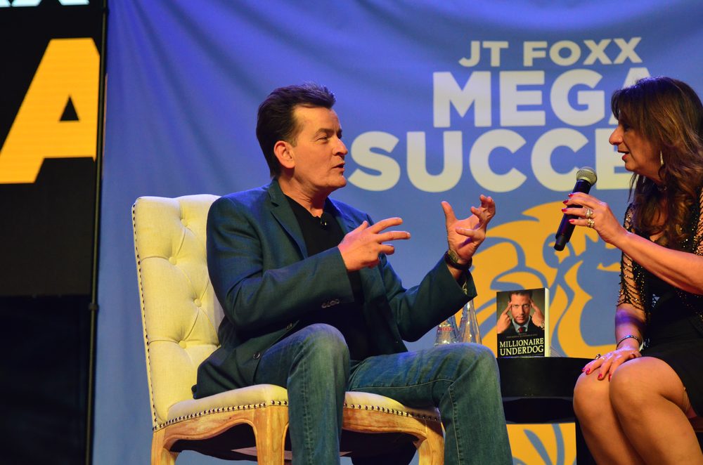 Dr. Dalal Akoury interviews actor Charlie Sheen on stage at an industry event
