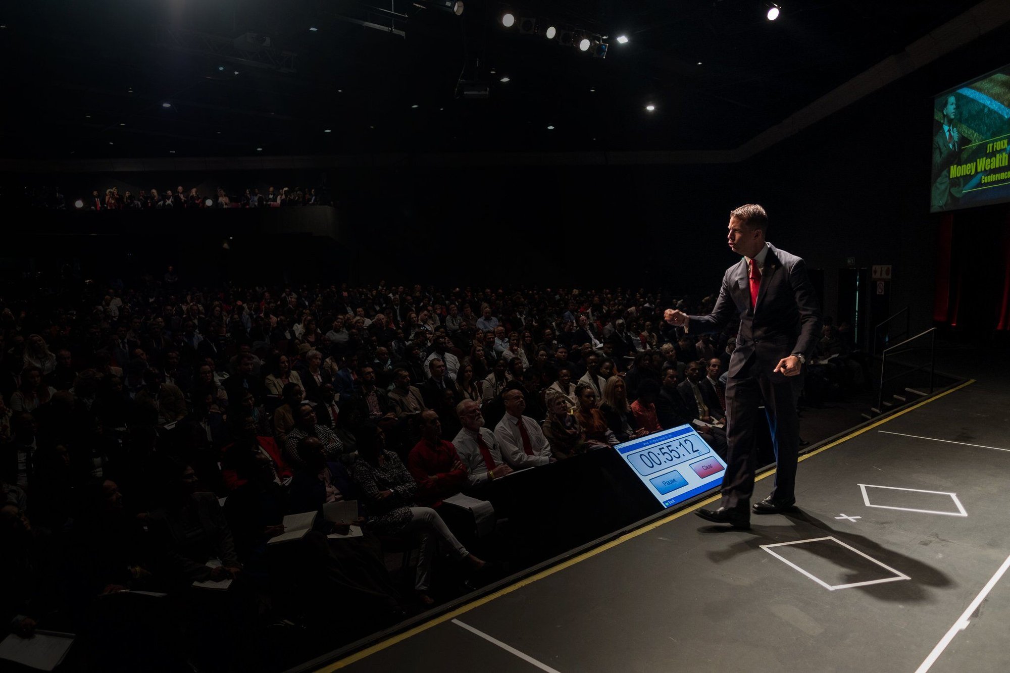 Speaker on stage addressing a large conference audience