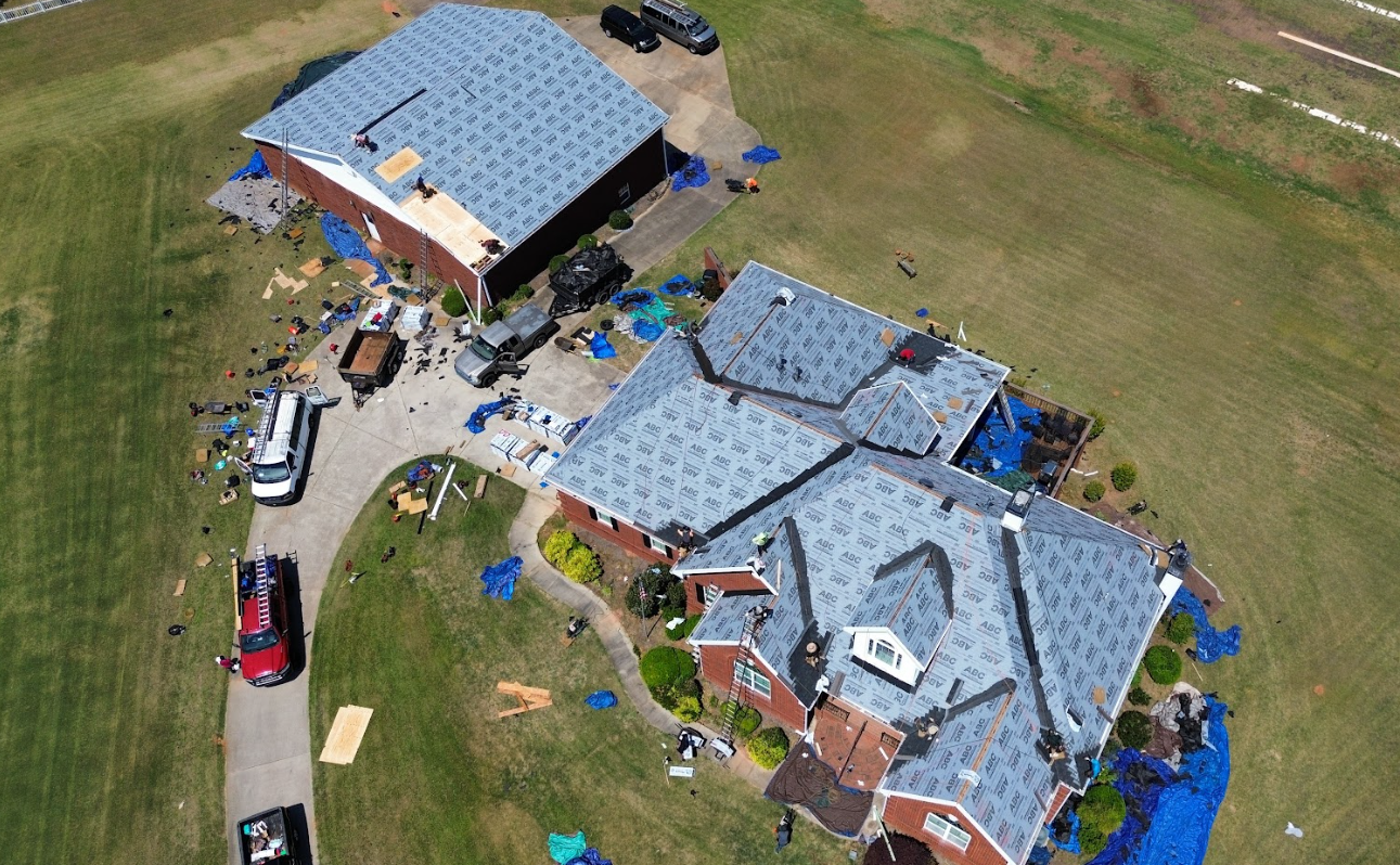 Aerial view of a CW2 Renovations insurance-claim roof replacement with materials staged across the property