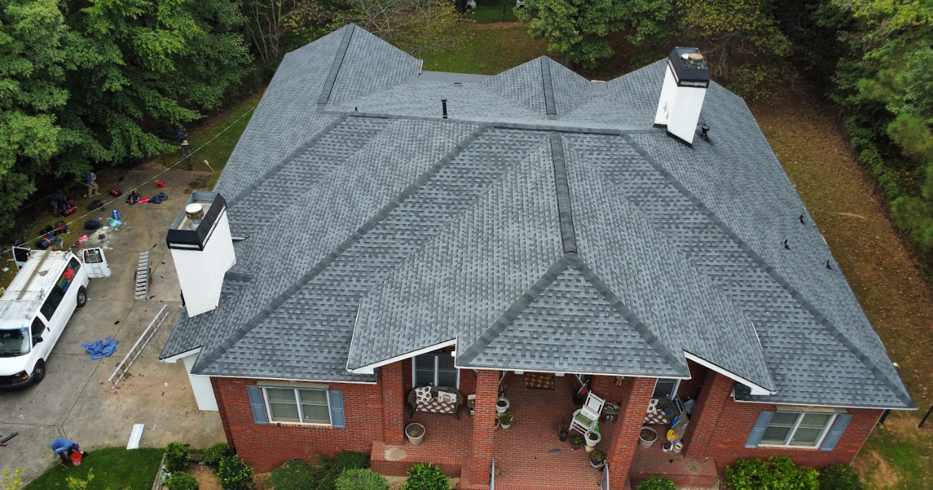 Aerial view of a finished asphalt roof on a brick home