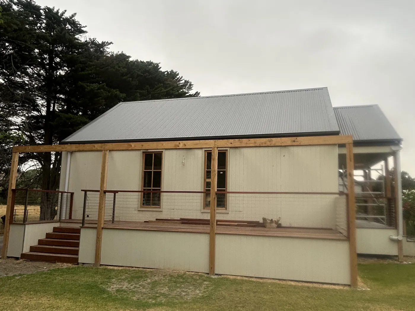 Cottage at Immerse Winery before painting, dingy weatherboard and raw timber framing