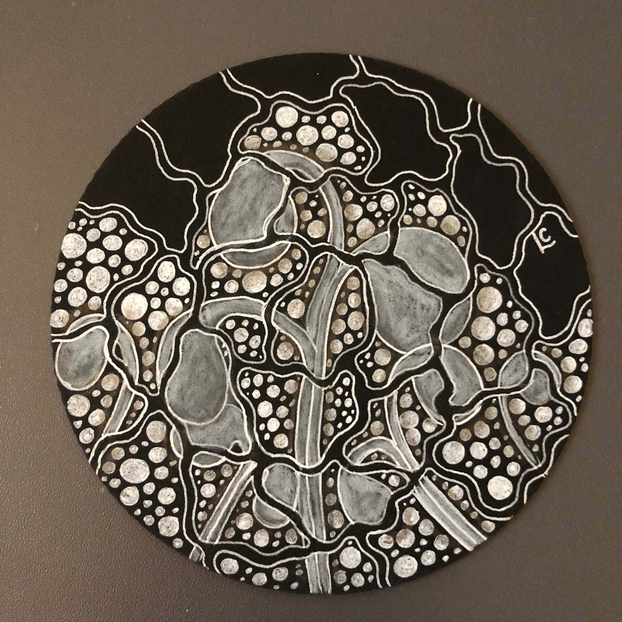 A black tile tangled on by Lisa Crow, a Certified Zentangle® Teacher
