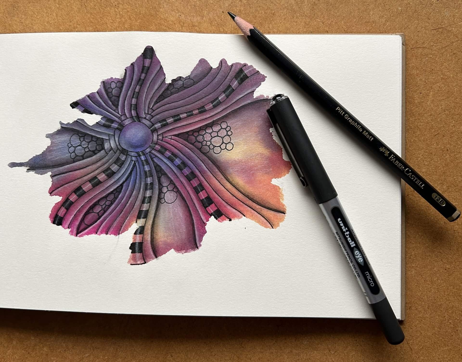 A page from a sketchbook with a Zentangle image created by Lisa Crow, a Certified Zentangle® Teacher. The image demonstrates the technique known as map tangling.