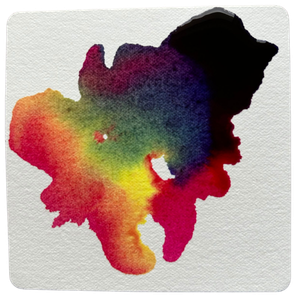 A paper tile with various colours of liquid watercolour drying on it.